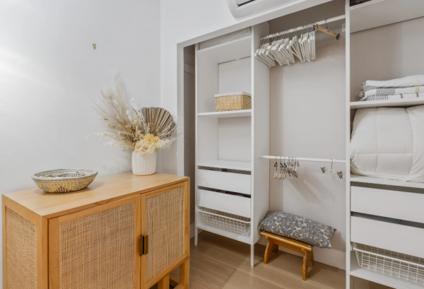 Lemari pakaian dengan desain ukiran elegan dan berwarna putih bersih